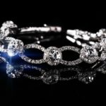 silver-colored accessory with clear gemstones on black surface