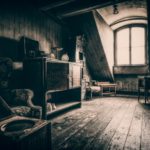 grayscale photo of wooden chair near window